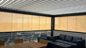 Pérgola bioclimática con cortina de cristal en Arenales